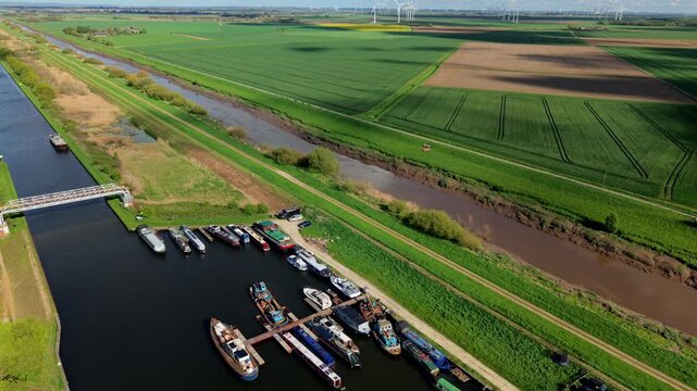 Drone shot of a large industrial chemical production plant and narrowboat marina under a green wind farm field