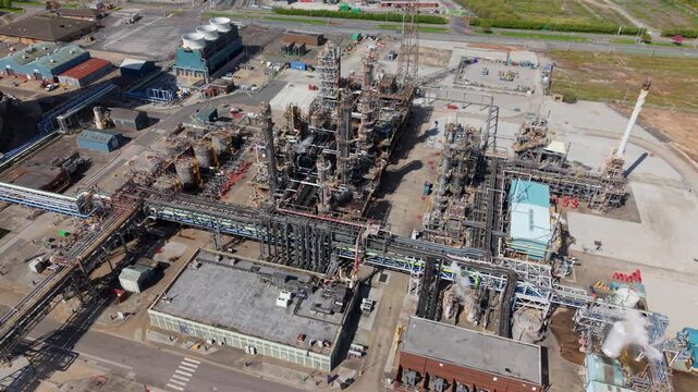 Drone shot of a massive chemical refining facility with large industrial silos and distribution pipelines