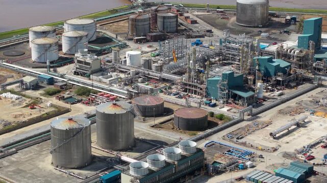 Drone shot of a massive chemical refining facility with large industrial silos and distribution pipelines