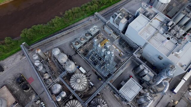 Aerial view of an industrial manufacturing factory with silos and piping on the banks of the River Aire UK