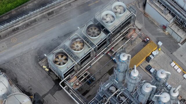 Close up aerial view of industrial turbine fans and vents rotating with steam rising in the UK