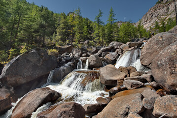 Russia, Western Buryatia, Eastern Sayan Mountains. A picturesque panorama of the Dabata mountain river rushing from the mountains at a 45-degree angle in countless cascades among huge boulders. © Александр Катаржин