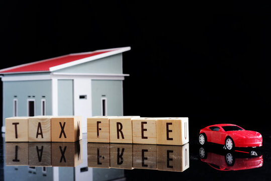 Miniature cars and miniature houses, with the words TAX FREE written on a dark background. Tax exemption with certain conditions.

