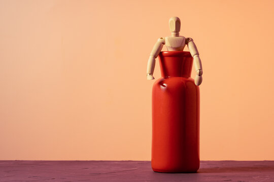 Artist mannequin climbing out of red ceramic vase, liberation and breakthrough theme