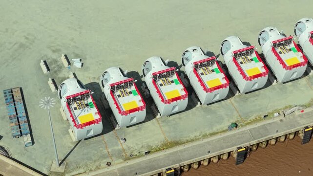 Close up aerial view of wind turbine nacelles lined up on a dock in a construction yard in Hull UK