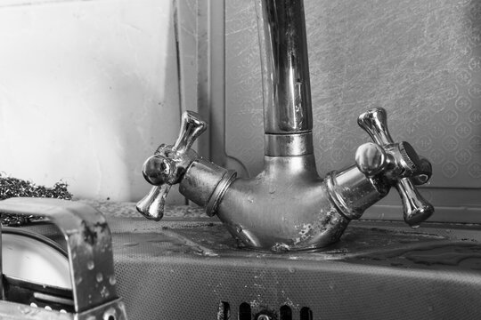 Old dirty chrome water faucet in the kitchen