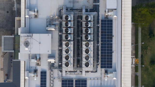 Aerial view of NTT Global Data Centers Thailand Limited rooftop featuring industrial cooling units, solar panels, and complex piping systems in Tambon Don Huaro, Chang Wat Chon Buri, Thailand.
