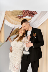 Fototapeta premium Young couple joyfully celebrating love in stylish attire amidst beautiful decor