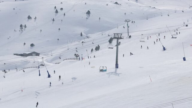 Skiers snowboarding down the snowy mountain in Pas de La Casa
