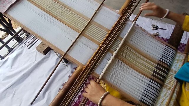 Handloom weaver working in her loom.	