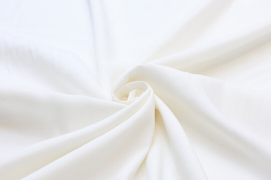 Premium white 100% natural viscose fabric texture with elegant, soft drapes. Lightweight, breathable textile background in vibrant colors. Ideal for fashion design, apparel manufacturing, and sewing.