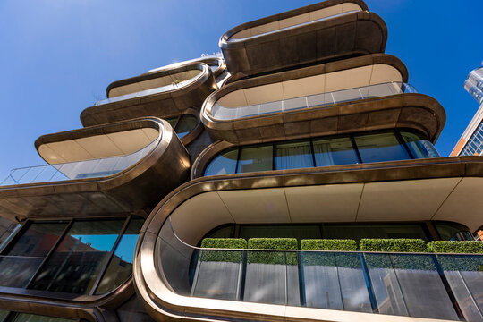 New York City, USA &mdash; April 11, 2026: A detailed low-angle view of Zaha Hadid&rsquo;s 520 West 28th Street showcases the intricate metallic curves and sculptural facade of this iconic West Chelsea residence.