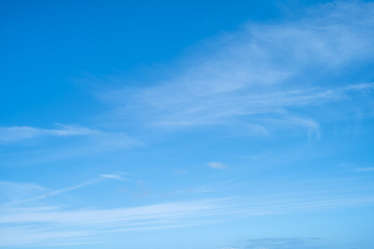 Blue sky background with very light whisky clouds.