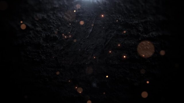 Glowing golden particles slowly moving over dark elegant texture