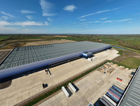 Aerial view of the large industrial warehouse with loading docks and surrounding green fields in Magna Park, England, United Kingdom.