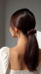 Naklejka premium Close up rear view of a woman with dark brown hair adorned with glitter and a scrunchie