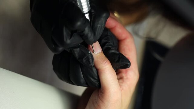 Men's manicure. Male hand undergoing a manicure procedure. The master does a man's manicure. A manicurist files a man's nails in a salon. Hygiene and hand care for men. Men's manicure design.