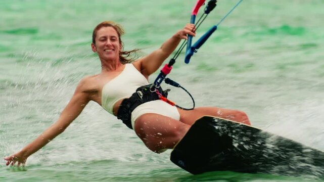 Sports woman kitesurfing in ocean in white bikini. Extreme summer sports