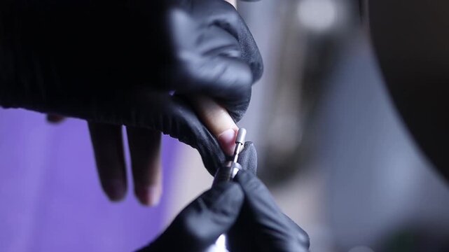 Women's manicure. Female hand undergoing a manicure procedure. The master does a women's manicure. A manicurist files a women's nails in a salon. Hygiene and hand care for woman. manicure design.