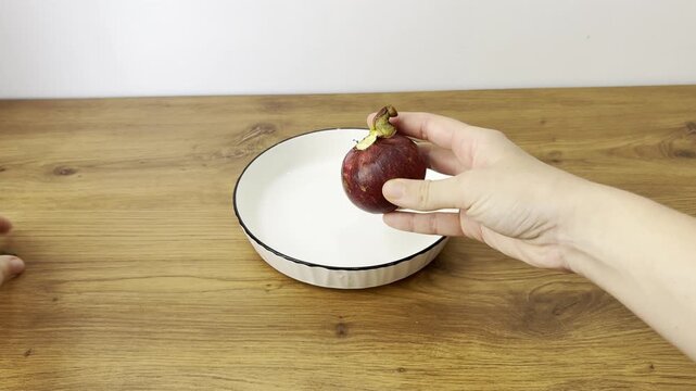 Horizontal close-up video of fresh mangosteen fruit. Exotic tropical fruit with purple rind and white segments