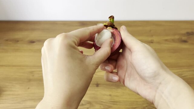 Horizontal close-up video of fresh mangosteen fruit. Exotic tropical fruit with purple rind and white segments
