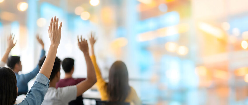 Multiple people raising hands actively participating in a classroom interaction session