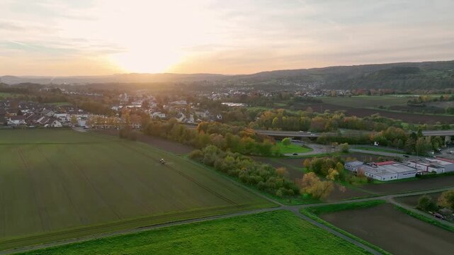 Aerial view of golden sunset casting a warm glow over fields, roads and a highway overpass, creating a stunning contrast, Neuwied, Rhineland-Palatinate, Germany.