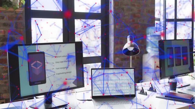 Loft desk showing monitors and laptop while network overlay moving across screens and brick wall