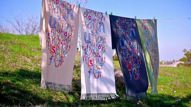 Traditional Armenian alphabet embroidery on textile hanging outdoors on clothesline