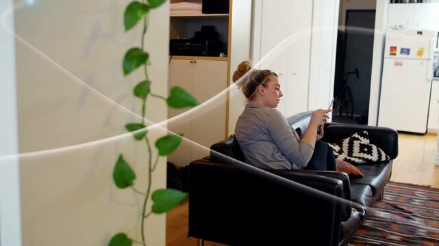 Woman sitting sofa raising phone, checking social messages while light streaks passing frame