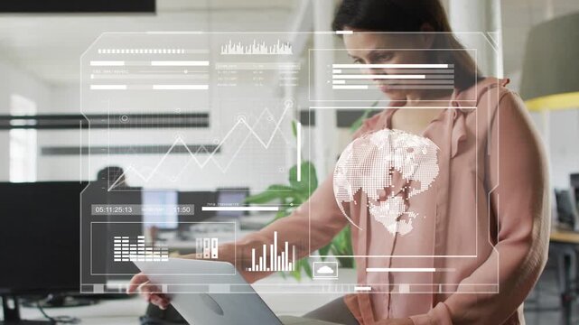 Woman standing desk working laptop, tapping pad sparking AR HUD globe charts analyzing tech