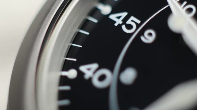 Macro close up of an automatic mechanical field watch with moving arms
