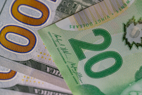 Macro shot of Canadian twenty dollar and US hundred dollar banknotes