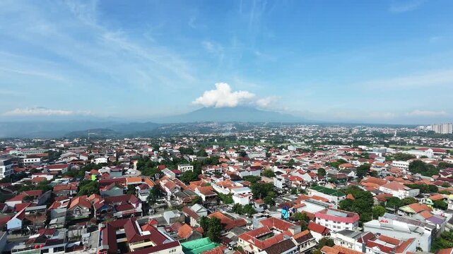 Aerial Panorama of Sprawling Cityscape with Volcanic Mountain in Distance.