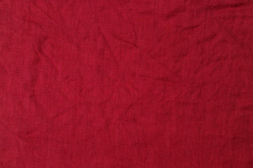 Fototapeta premium Solid red fabric with slight texture lying flat on a surface in a well-lit area during the day