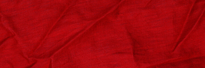 Bright red fabric with creases in texture showing folds and layers in a textile study environment...