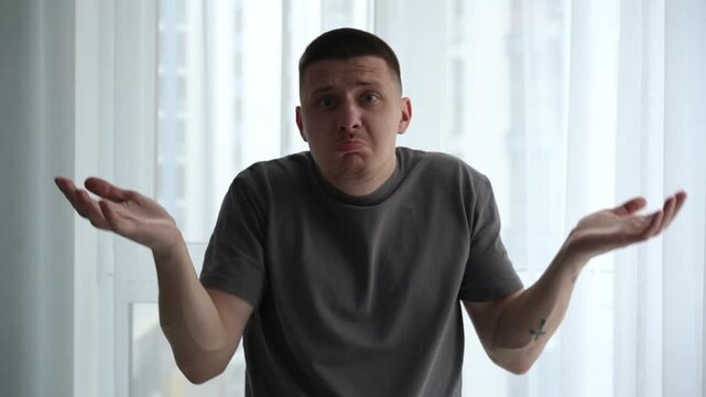 Man expressing confusion and disbelief, raising his hands in a questioning gesture, showing he does not understand the situation. Concept of misunderstanding and uncertainty.