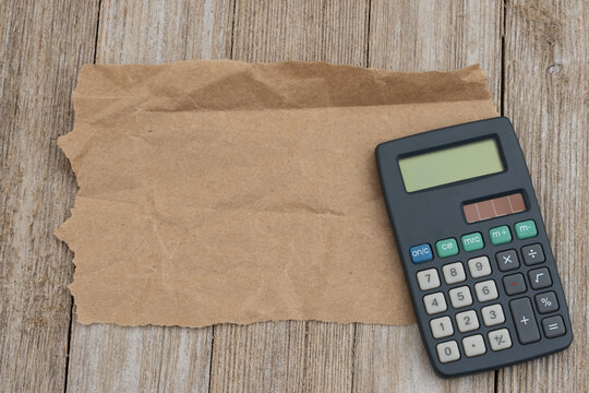 Calculator on kraft paper on wood desk