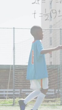 Vertical video: Boy in lightblue kit running near goal after play, sports graphs rising over team