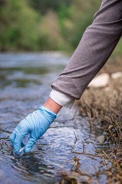 vertical Environmental engineer performing water sampling for pollution analysis