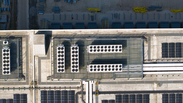 Aerial view of the rooftop of a supermarket distribution centre featuring HVAC cooling units and solar panel arrays Nailstone, Nuneaton, United Kingdom.