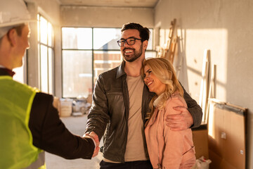 Fototapeta premium Couple meets construction manager in new home during afternoon light in modern building