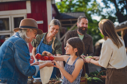 Buying organic produce and jam at local farmers market.