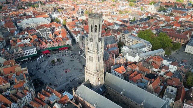 Aerial drone footage of the historic Markt square in Bruges, Belgium. Featuring the medieval Belfry tower (Belfort), colorful guild houses, and the Provincial Court building . Version 7.