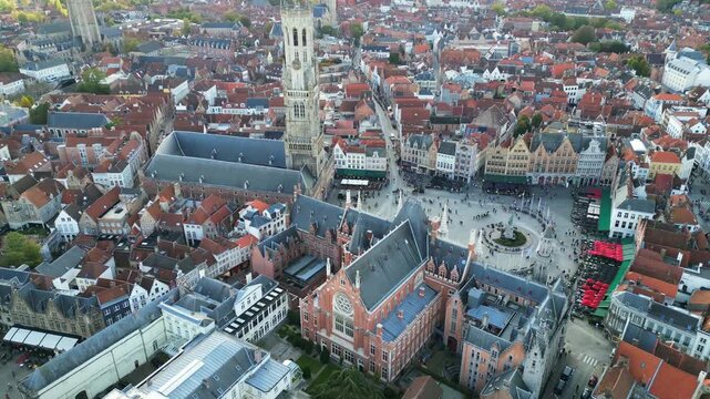 Aerial drone footage of the historic Markt square in Bruges, Belgium. Featuring the medieval Belfry tower (Belfort), colorful guild houses, and the Provincial Court building . Version 5.
