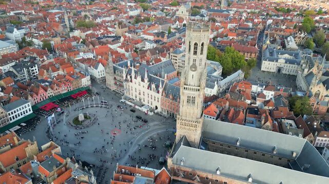Aerial drone footage of the historic Markt square in Bruges, Belgium. Featuring the medieval Belfry tower (Belfort), colorful guild houses, and the Provincial Court building . Version 4.