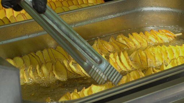 French Fries Cooking in Hot Oil, Close-Up of Potato Sticks Frying in Deep Fryer