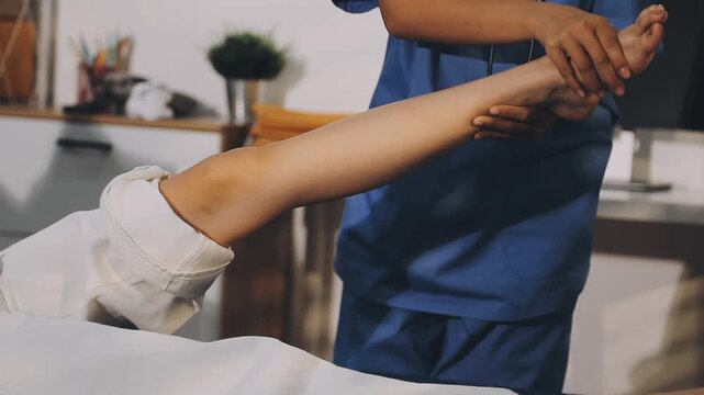 Doctor examining leg of female patient in examination room