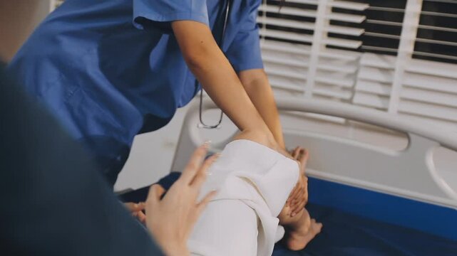 Doctor examining leg of female patient in examination room