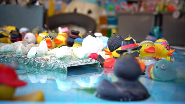 Schwimmende Gummienten in verschiedenen Outfits bunte Jahrmarkt Spielszene 